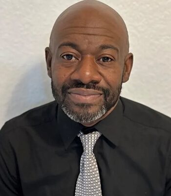 A man with a black shirt and tie