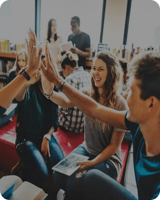 A group of people sitting on the floor and giving each other five.