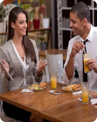 A group of people sitting at a table eating food.