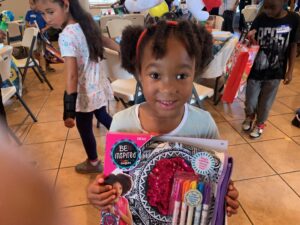 A little girl holding up her gift bag