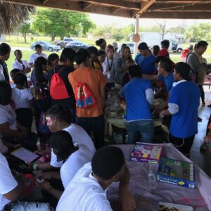 A group of people gathered around tables with papers.