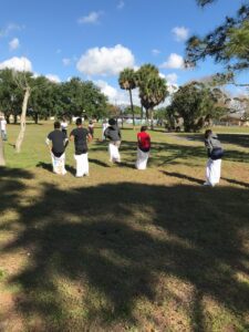 A group of people standing in the grass.