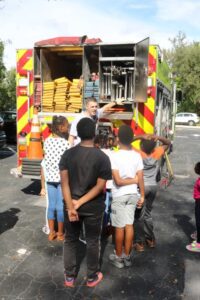 A group of people standing around a fire truck.