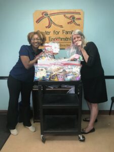 Two women standing next to a table with boxes of baby supplies.