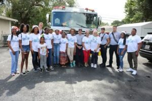 A group of people standing in front of a fire truck.