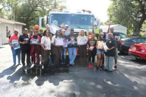 A group of people standing around a fire truck.